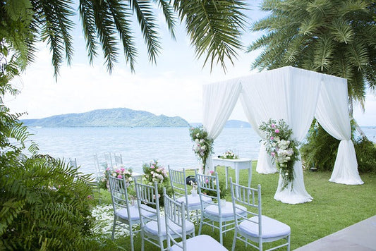Outdoor wedding ceremony setting on cliff overlooking the water and mountains.