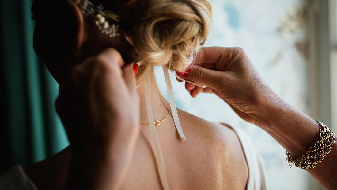 Mum tying her daughter bride bun hairstyle.