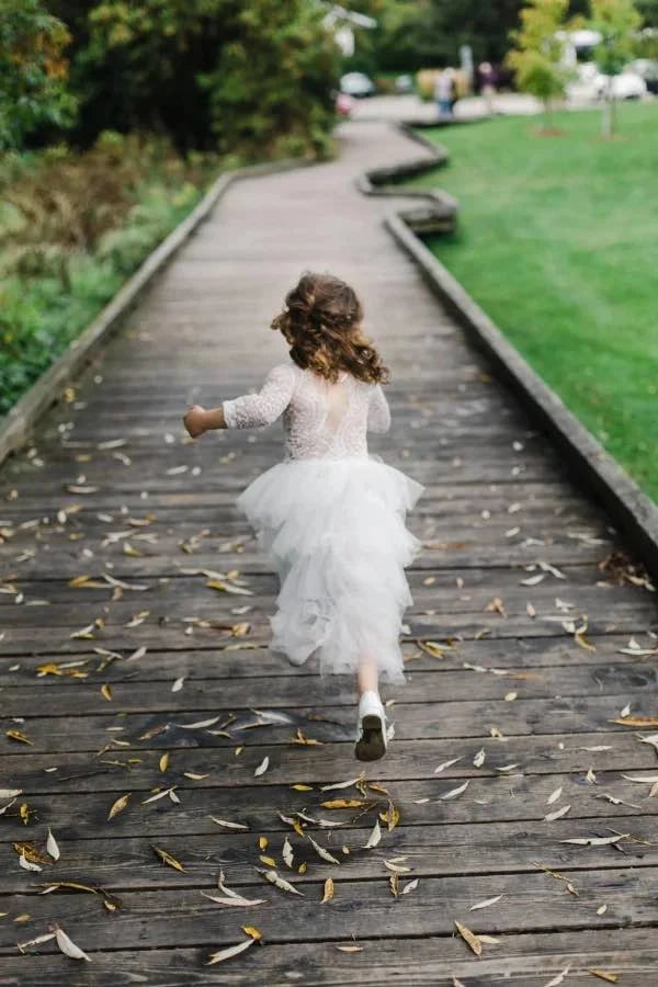 Little girl in flower girl birthday dress running away
