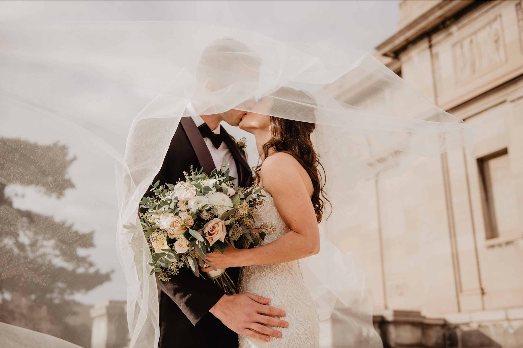 Bride and Groom Kissing under the Veil