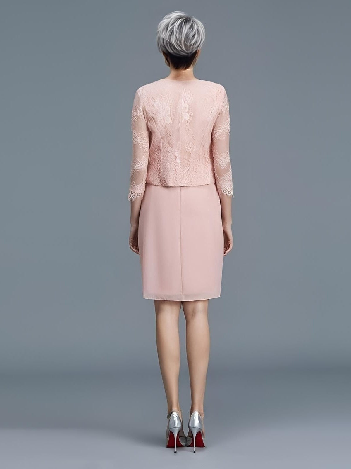 Older woman with short gray hair from back in light pink knee lenght dress and lace jacket
