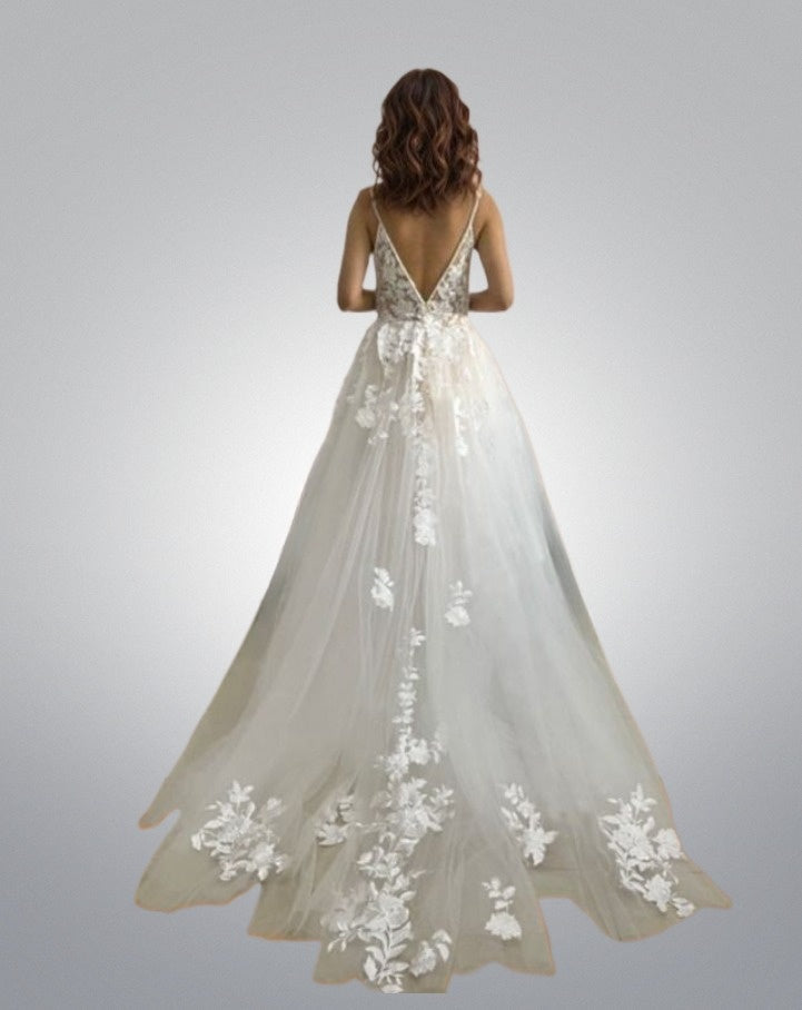 Bride in tulle beach wedding dress with lace appliques on skirt and train