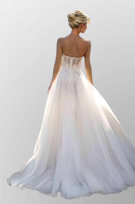 Backless Boho Wedding Dress on Beach: The model displays the backless design of the gown, with the sweep train trailing behind her.