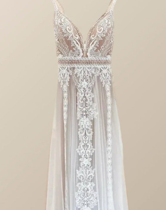 Boho Wedding Dress on hanger focusing on the V-neckline and symmetrical lace details on the skirt