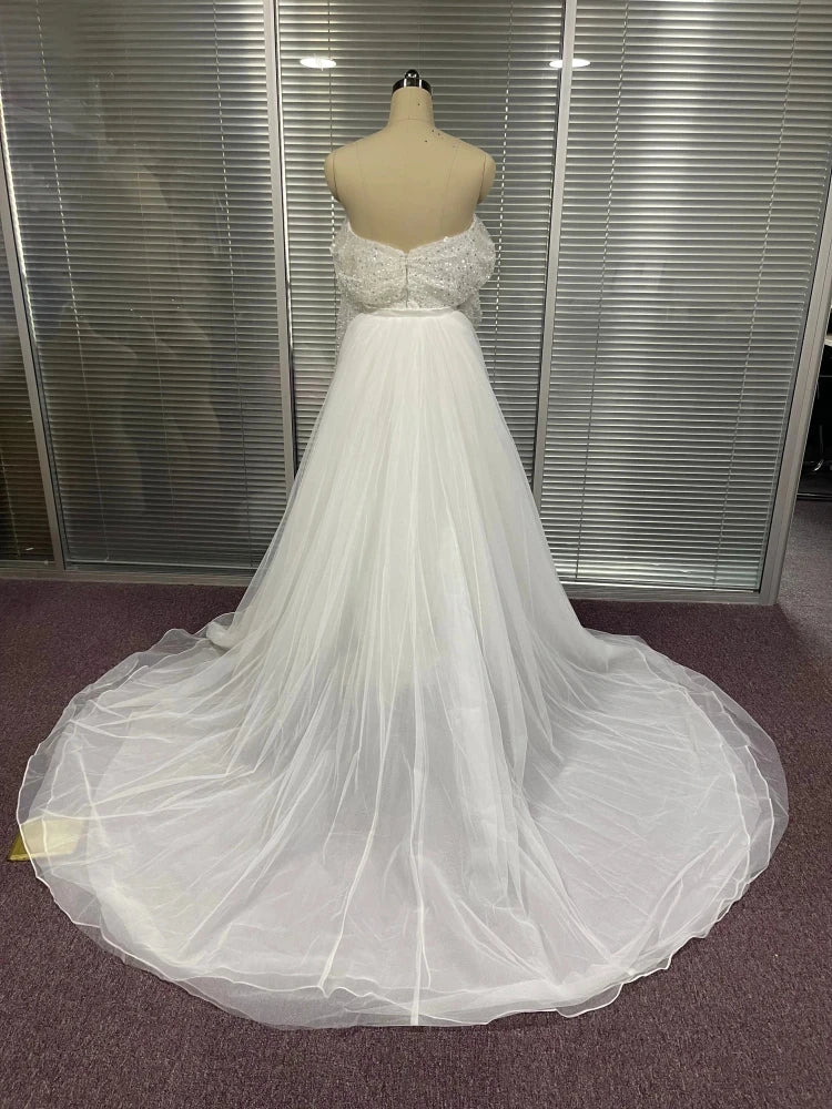 Back detail of sequined off-the-shoulder mermaid gown with a detachable tulle overskirt.