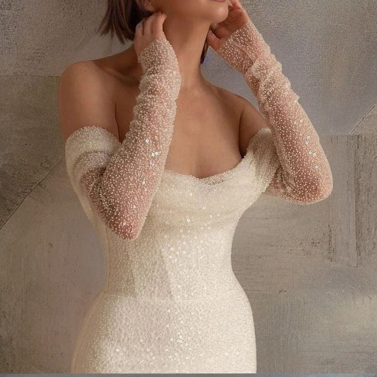 Bride wearing a beaded off-the-shoulder mermaid gown with ruched bodice.