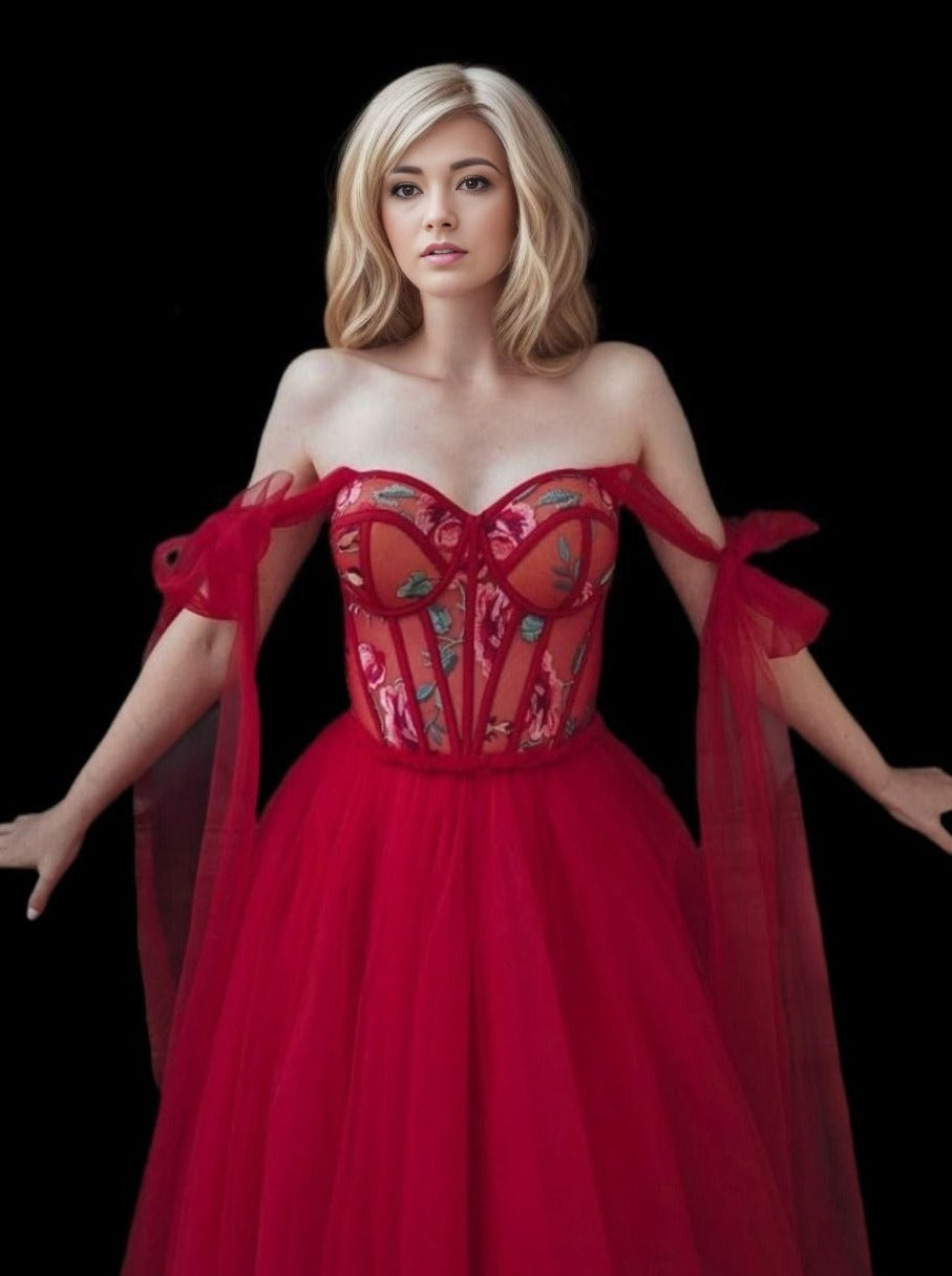 Bride or model showcasing bright red wedding dress with bow straps.