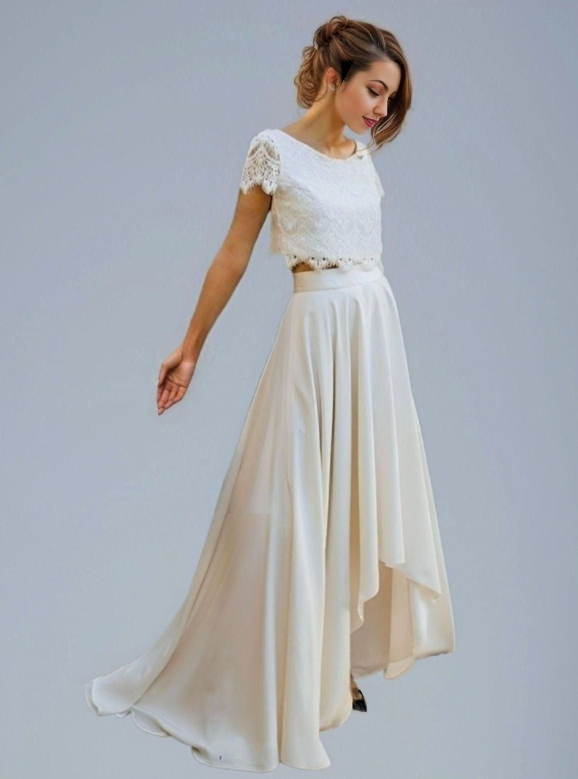 Woman in 2 piece separate wedding dress with short cap lace sleeves, and a beautiful lace top, paired with a flowing assymetrical skirt.