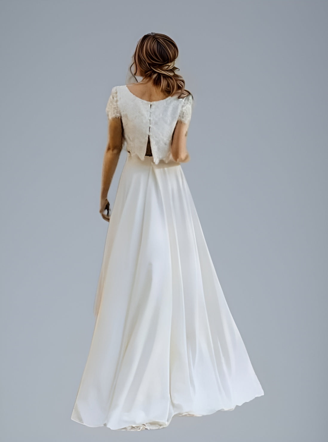 Woman from back in Elegant two-piece wedding gown featuring a lace top with a button-back design and an open back.
