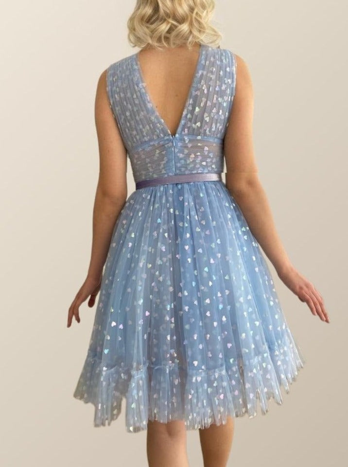 Bak of chic above-knee dress with tulle, holographic hearts, and a pleated A-line silhouette, ideal for celebrations or formal events.