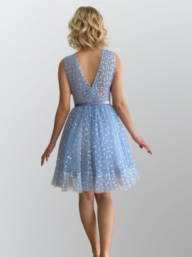 Woman from back in sophisticated dress featuring tulle with glitter, a built-in bra, and a tiered A-line skirt, perfect for a special celebration.