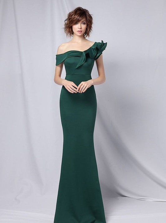 Girl in sophisticated emerald green formal dress with a trumpet/mermaid silhouette, ruffled neckline, and off-the-shoulder sleeve style, perfect for special occasions.