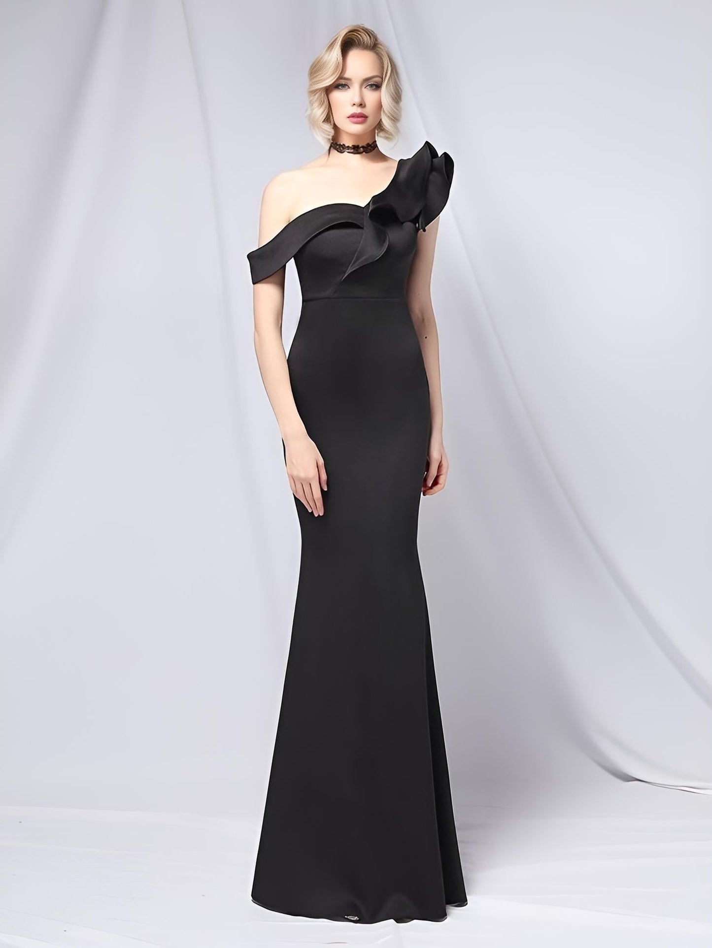 Woman in black off-the-shoulder formal dress with neckline ruffles, in a flattering fit.