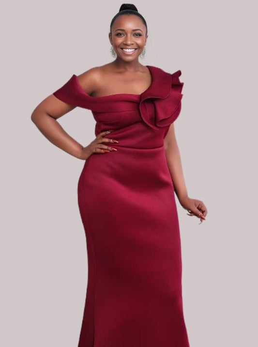 Plus size woman in formal gown with a trumpet/mermaid silhouette and ruffled off-the-shoulder sleeves, designed for a sophisticated look.