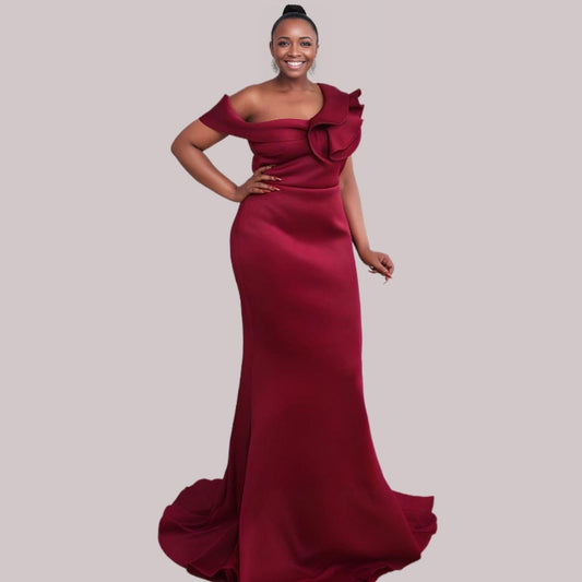 Woman in burgundy elegant one-shoulder gown with ruffles, ideal for prom or bridal parties, featuring a trumpet silhouette.