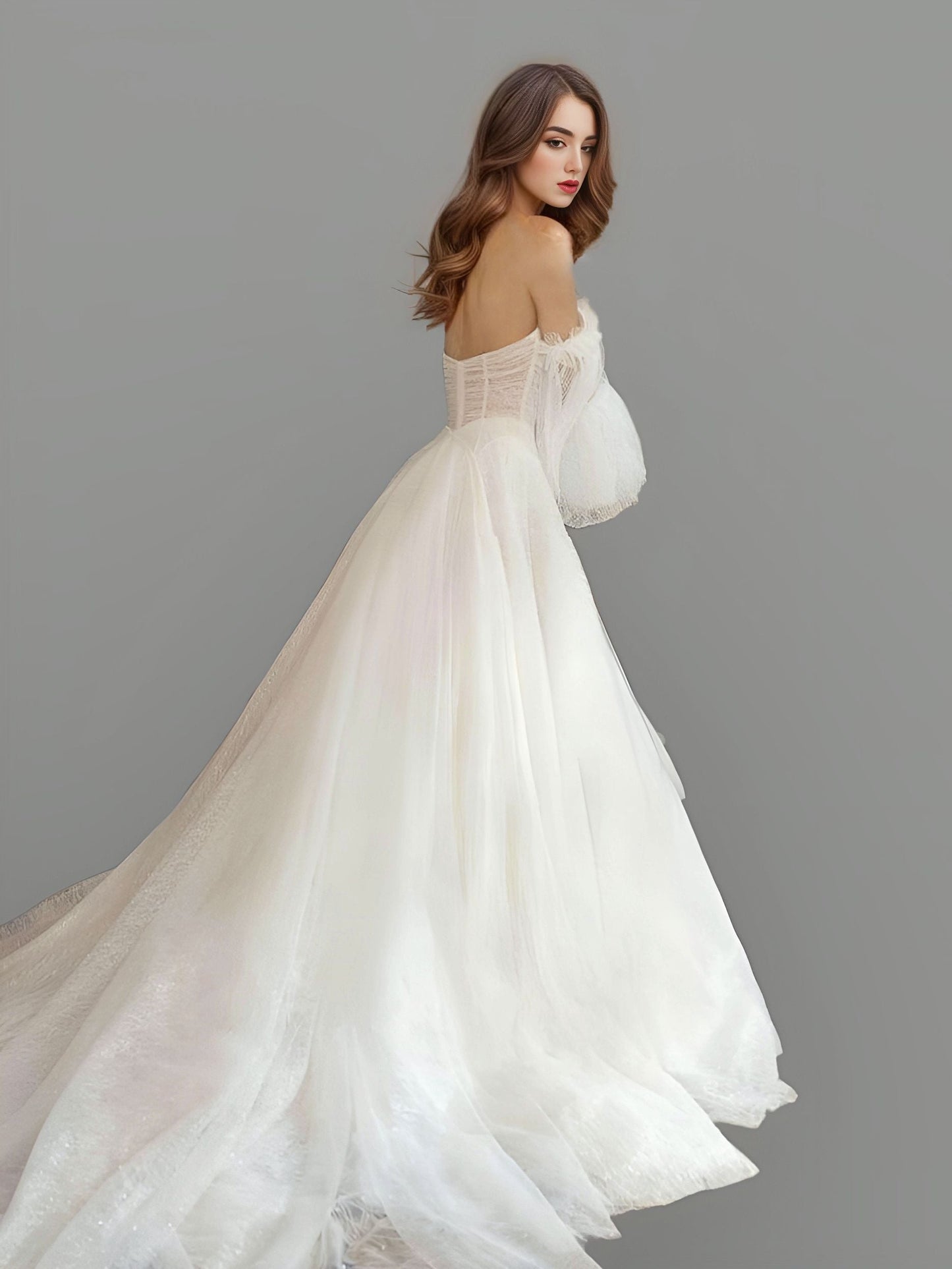 Bride showing a backless wedding gown made from glittered tulle, featuring a sweetheart neckline and flowing chapel train for a grand entrance.