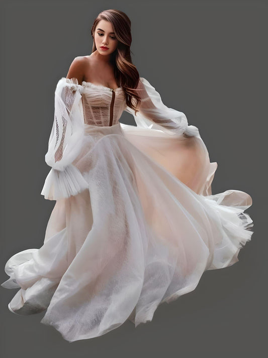 Model wearing an off-shoulder wedding dress with puff sleeves and a chapel train, made entirely of glittered tulle for a fairytale wedding.