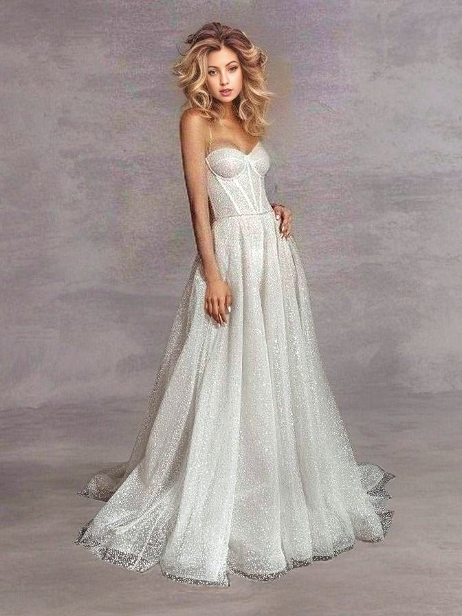 Model wearing a glitter tulle A-line wedding dress with spaghetti straps and a sweep train, perfect for a glamorous and elegant wedding.
