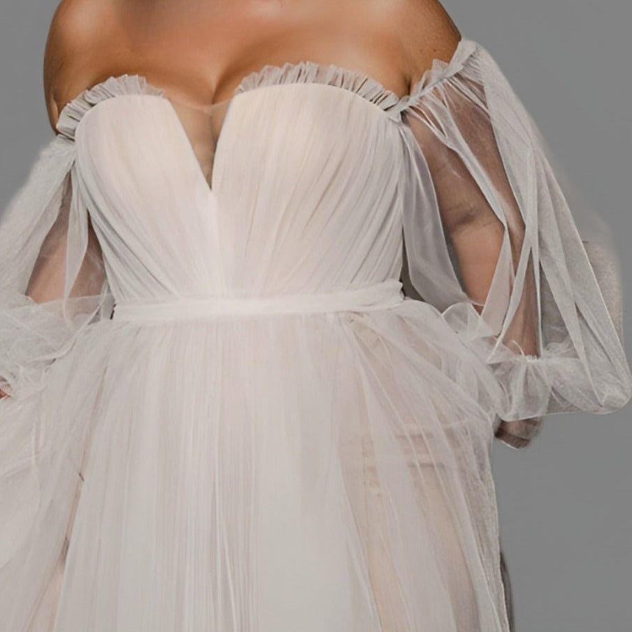 Detail of woman wearing plus-size boho wedding gown with long puff sleeves and ruched details.