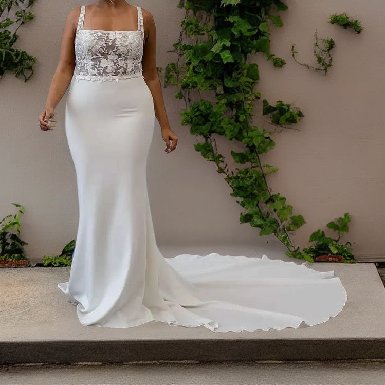 Woman in a wedding gown with a mermaid silhouette and square enckline, with a sweep train, ideal for a boho-inspired wedding.