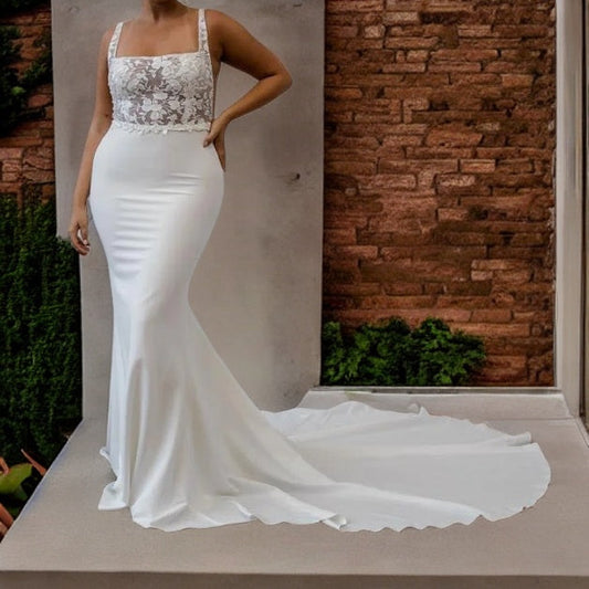 Plus size model showcasing a satin mermaid wedding gown with lace appliques, square neckline, and backless design, perfect for a boho-chic bride.