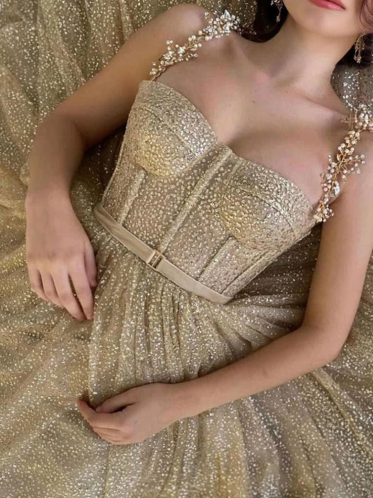 Elegant gold tulle gown featuring a fitted bodice, beaded spaghetti straps, perfect prom or formal party look.