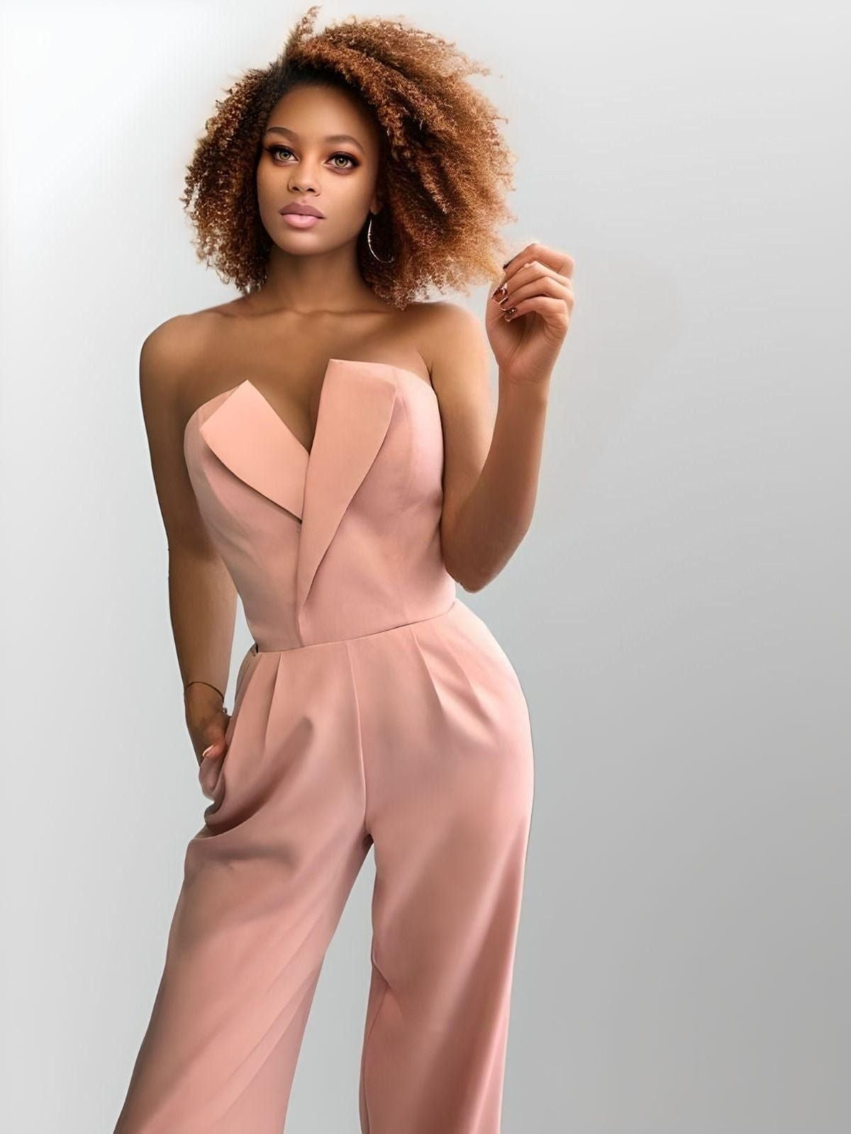 Close up of woman wearing pink elegant strapless jumpsuit with a deep V-neck, ideal for formal occasions or bridal events.
