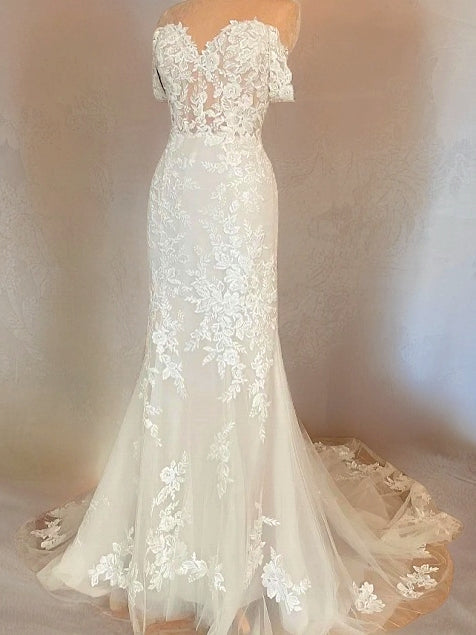 Bridal gown with full floral lace, off-the-shoulder sweetheart neckline, and court train arranged on a mannequin.