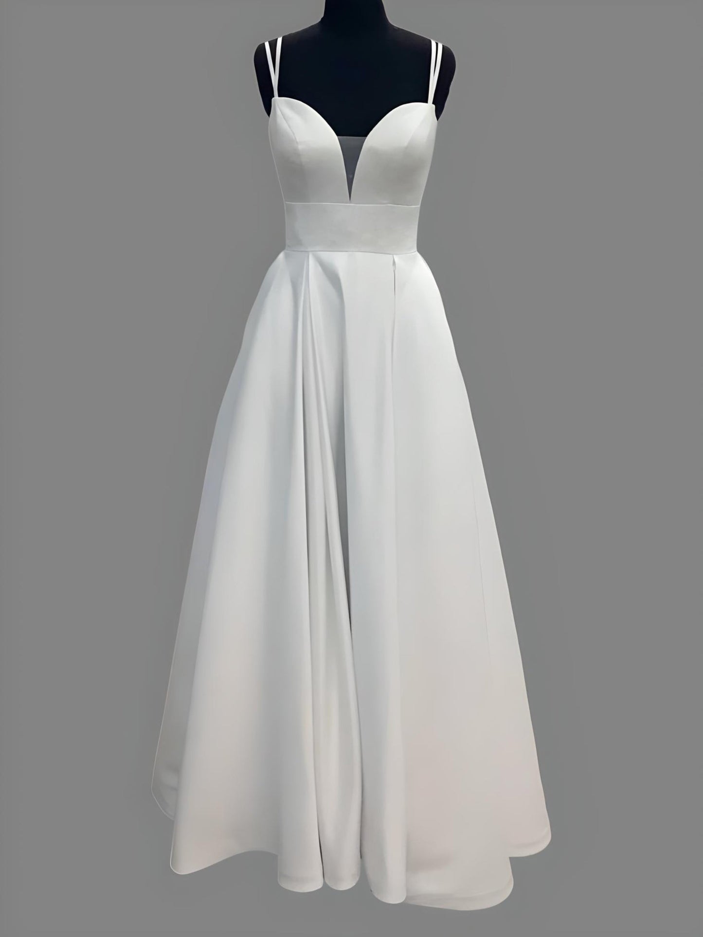 Mannequin with a simple elegant A-line wedding gown with a sweetheart neckline and V cutout.