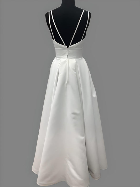 Elegant bridal gown on a mannequin featuring a sweetheart neckline, double spaghetti straps, and a flowing A-line skirt, ideal for minimalist and boho-inspired weddings.