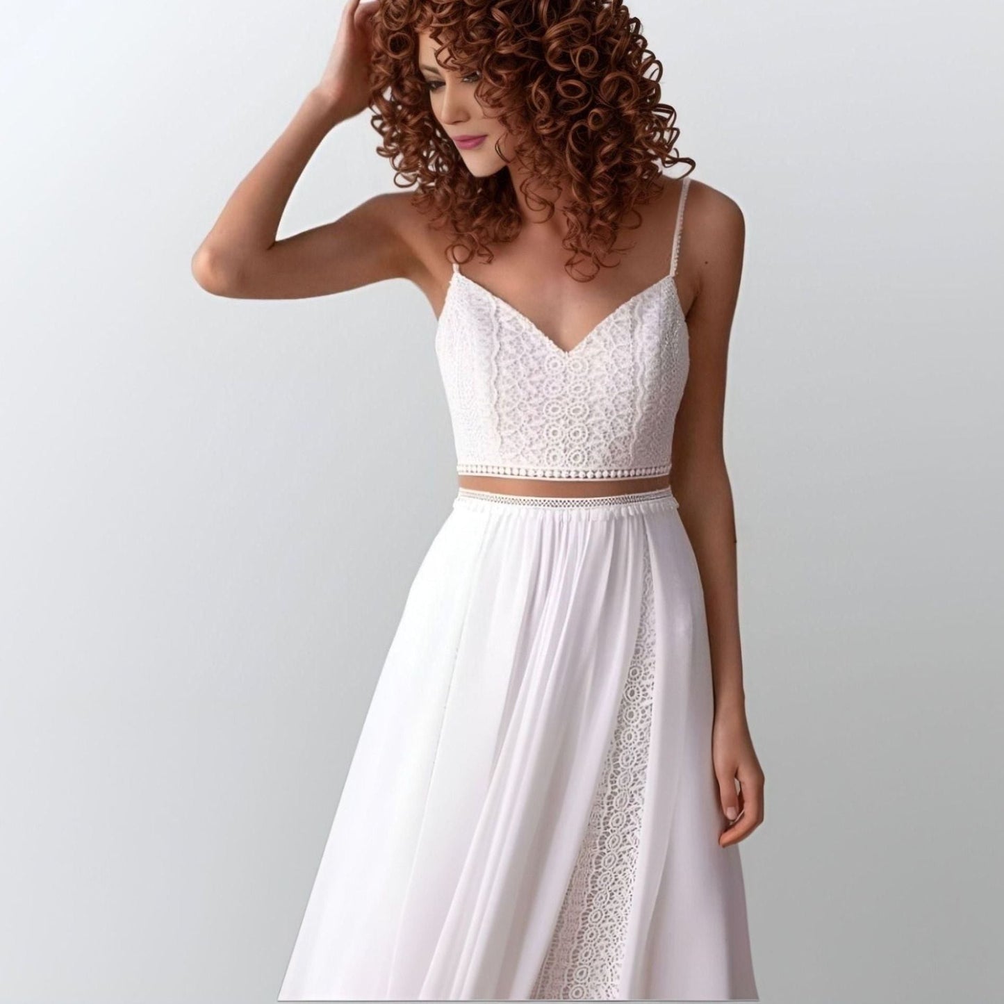 Elegant chiffon wedding dress featuring an illusion lace top, flowing skirt with geometric lace, and spaghetti straps, designed for a beach or boho-inspired wedding.