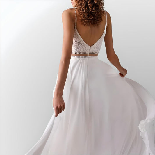 Woman from back in elegant boho wedding dress featuring a lace top with illusion waist, spaghetti straps.
