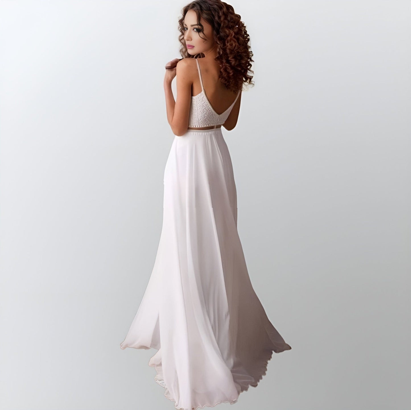 Bride wearing a bohemian-inspired chiffon wedding gown with an illusion of separate two piece dress, and backless design.