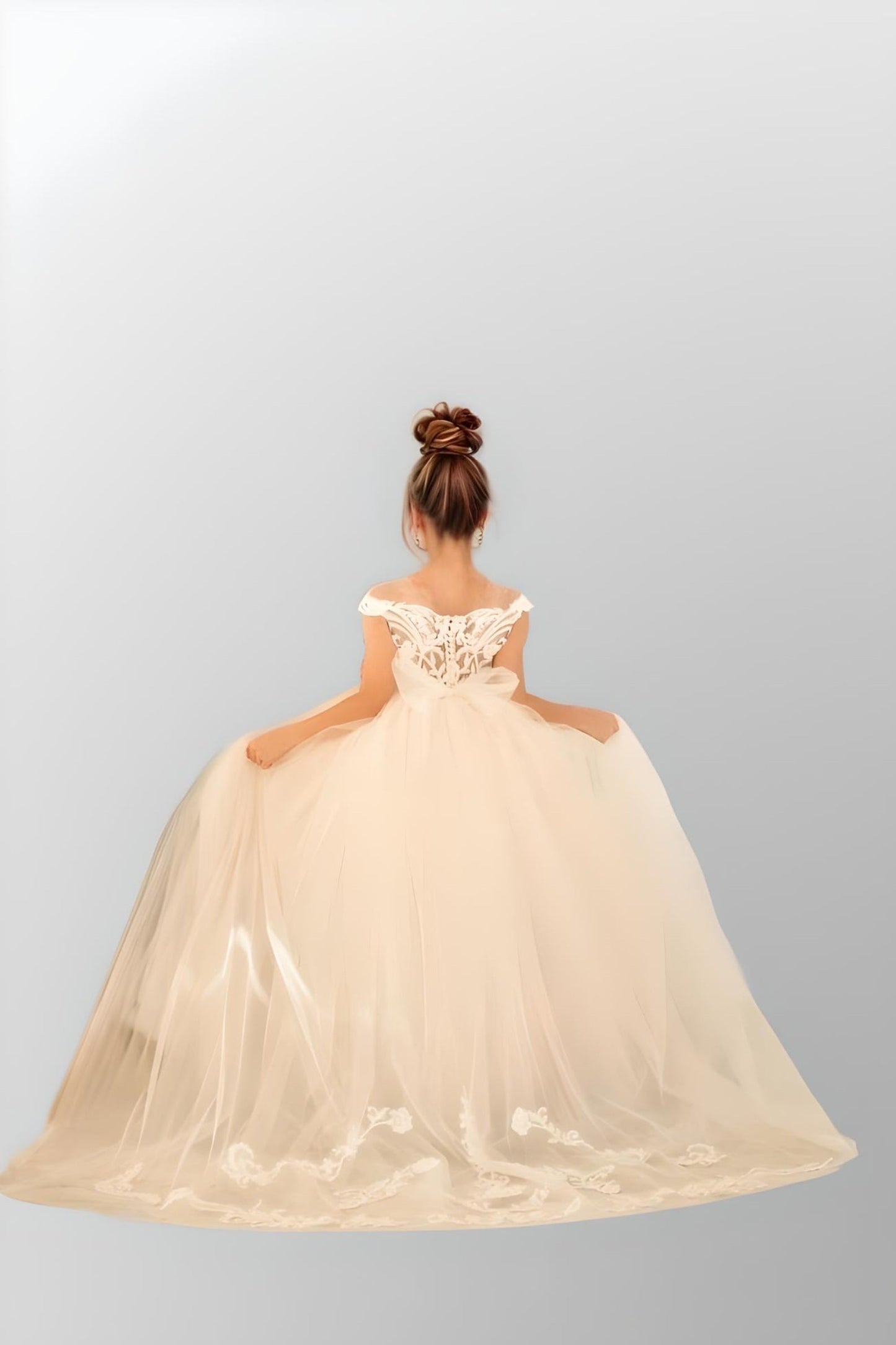 Child wearing an elegant off-shoulder dress with tulle and lace, bow details, ideal for flower girls and special occasions.