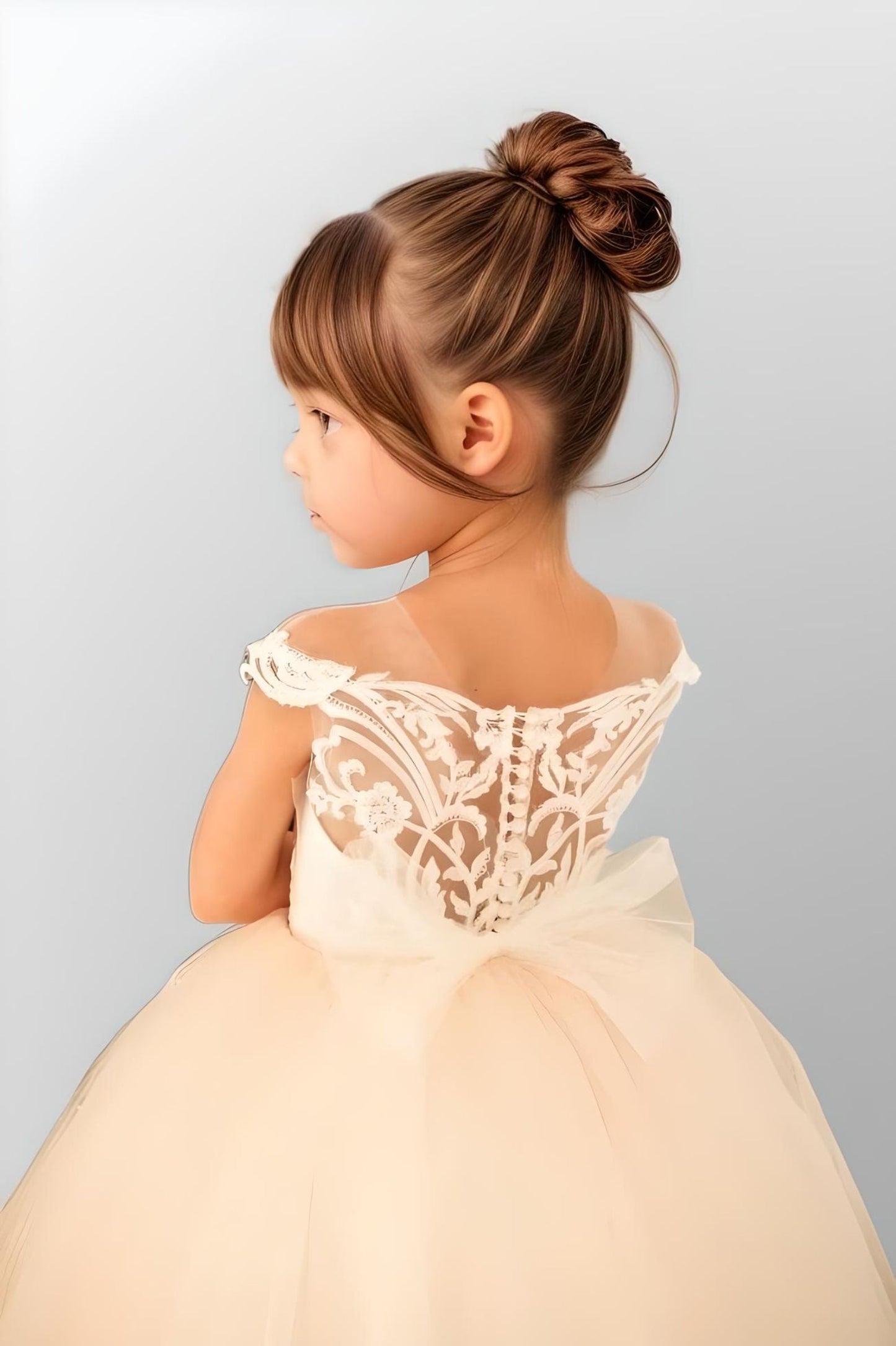 Young girl in a princess-inspired gown featuring off-shoulder design and lace bow, crafted from lightweight tulle for a beautiful and timeless look.