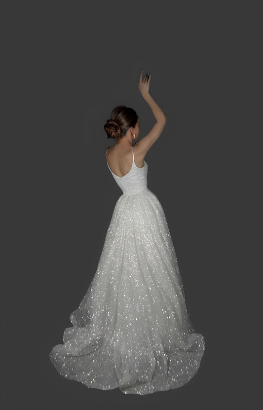 Model posing in the sparkling wedding dress, with a back close-up on the train and spaghetti straps.