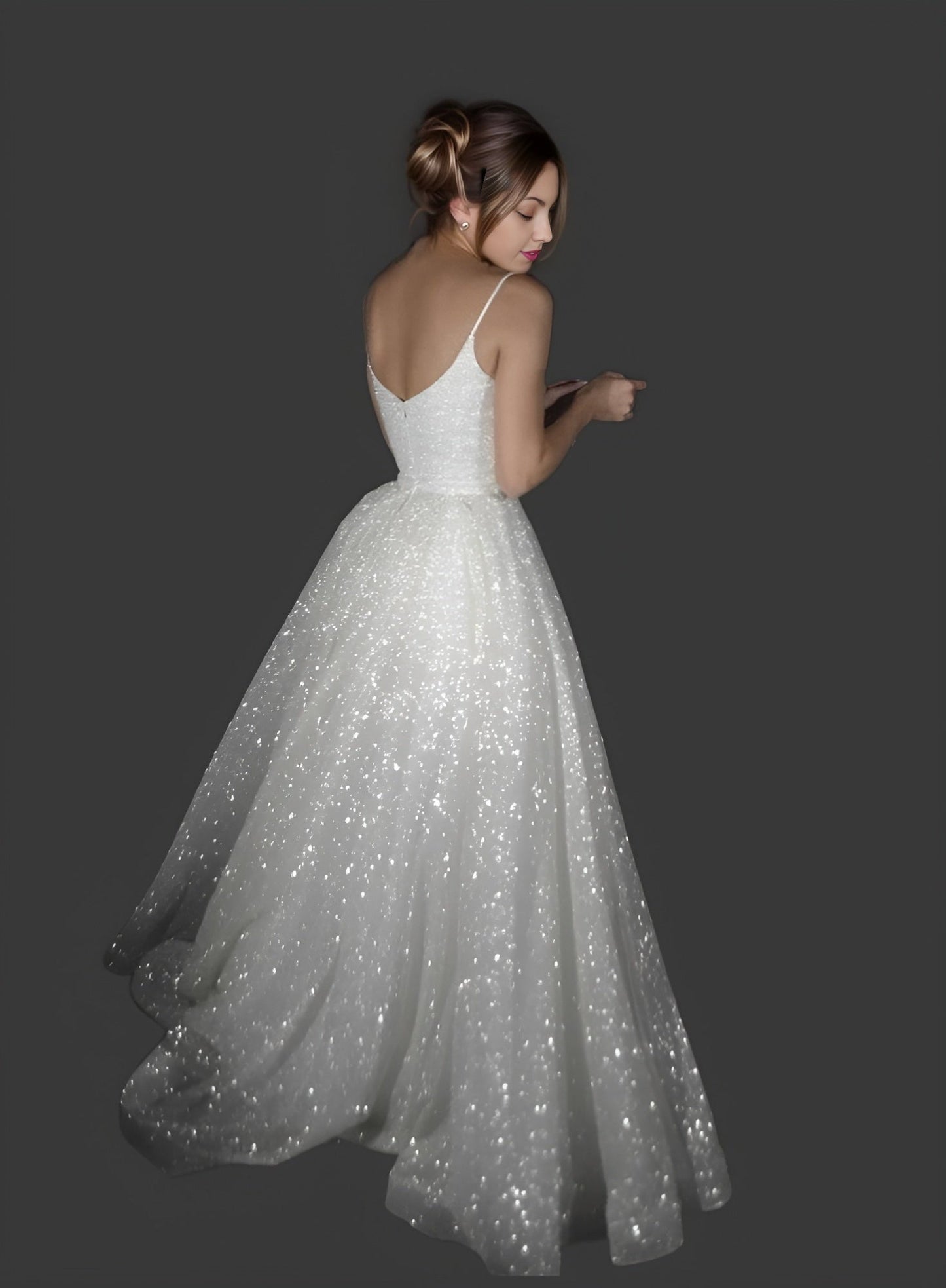 Model showcasing a spaghetti strap bridal glitter gown with a V-neckline, standing from back.