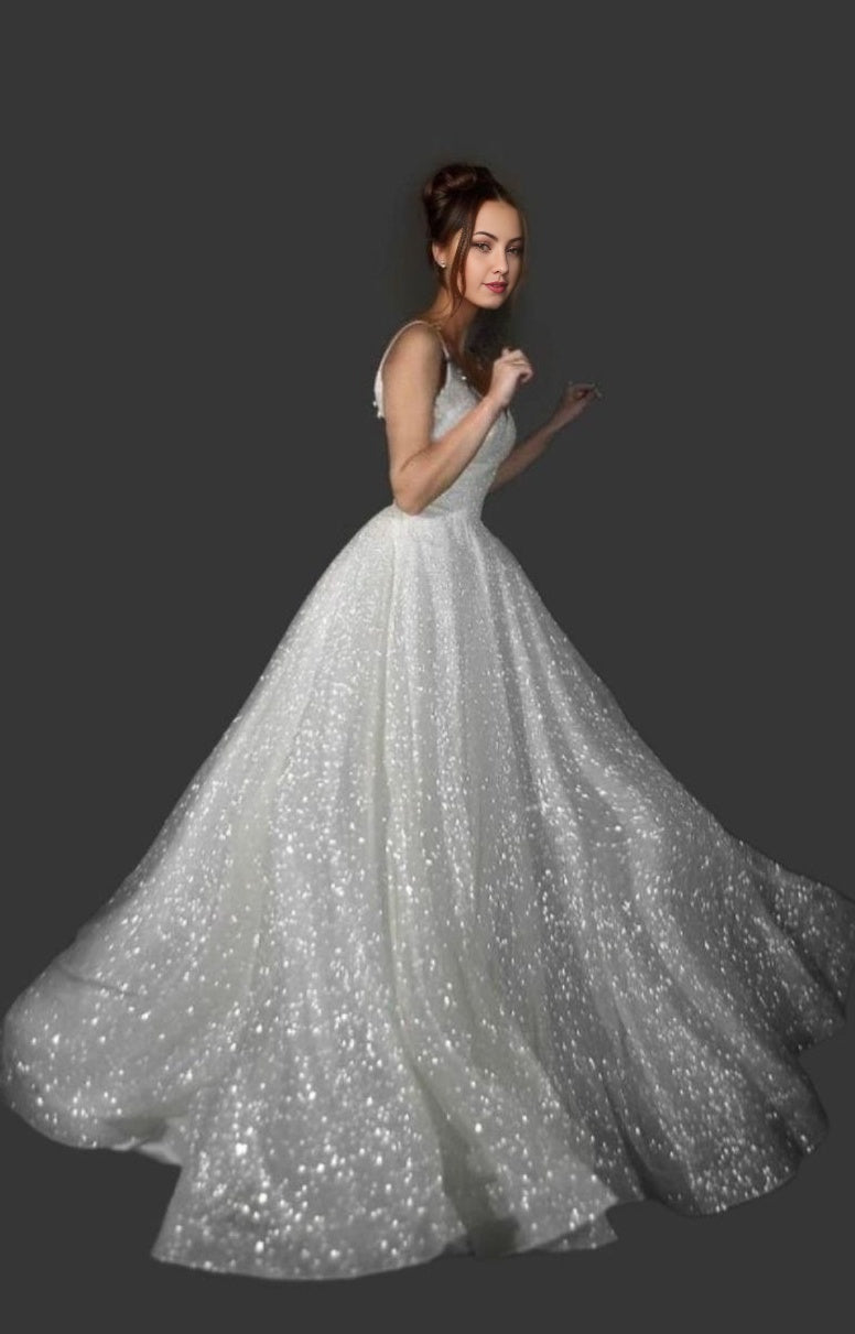 Elegant woman in a sparkling tulle A-Line wedding gown, dancing with a soft smile