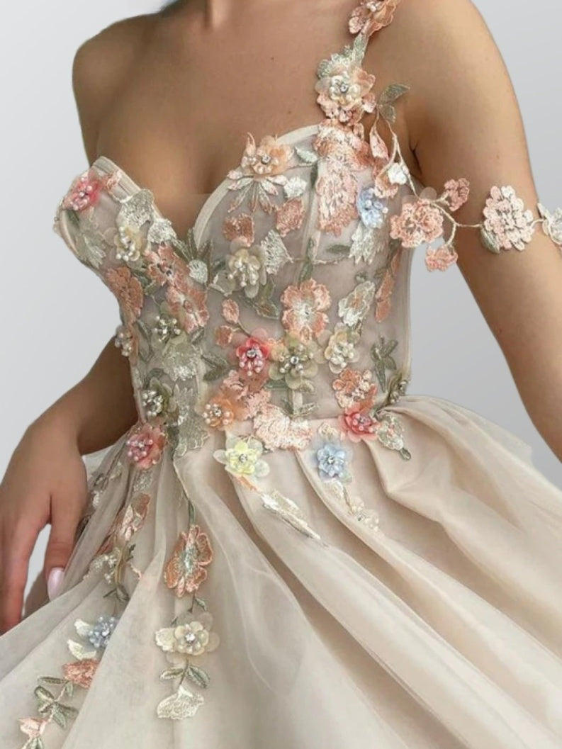 Woman in LIBBY gown in detail shot, showing floral appliques - elegant evening wear in champagne.