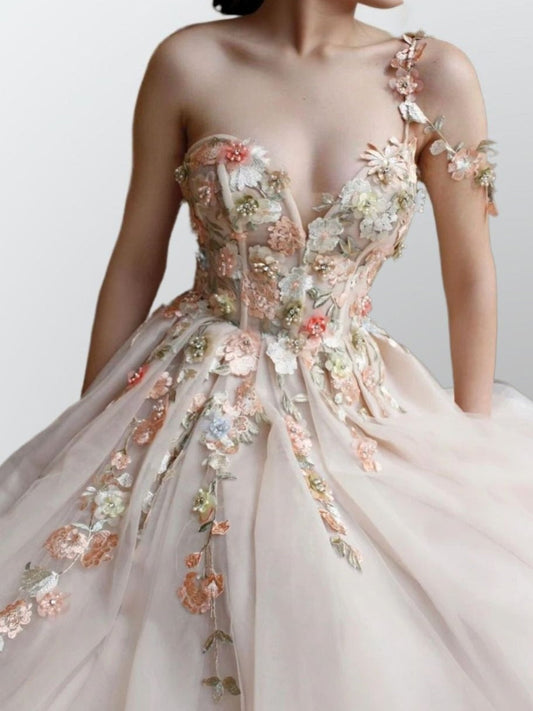 Close-up of handmade floral appliques on LIBBY champagne tulle gown, with elegant neckline.