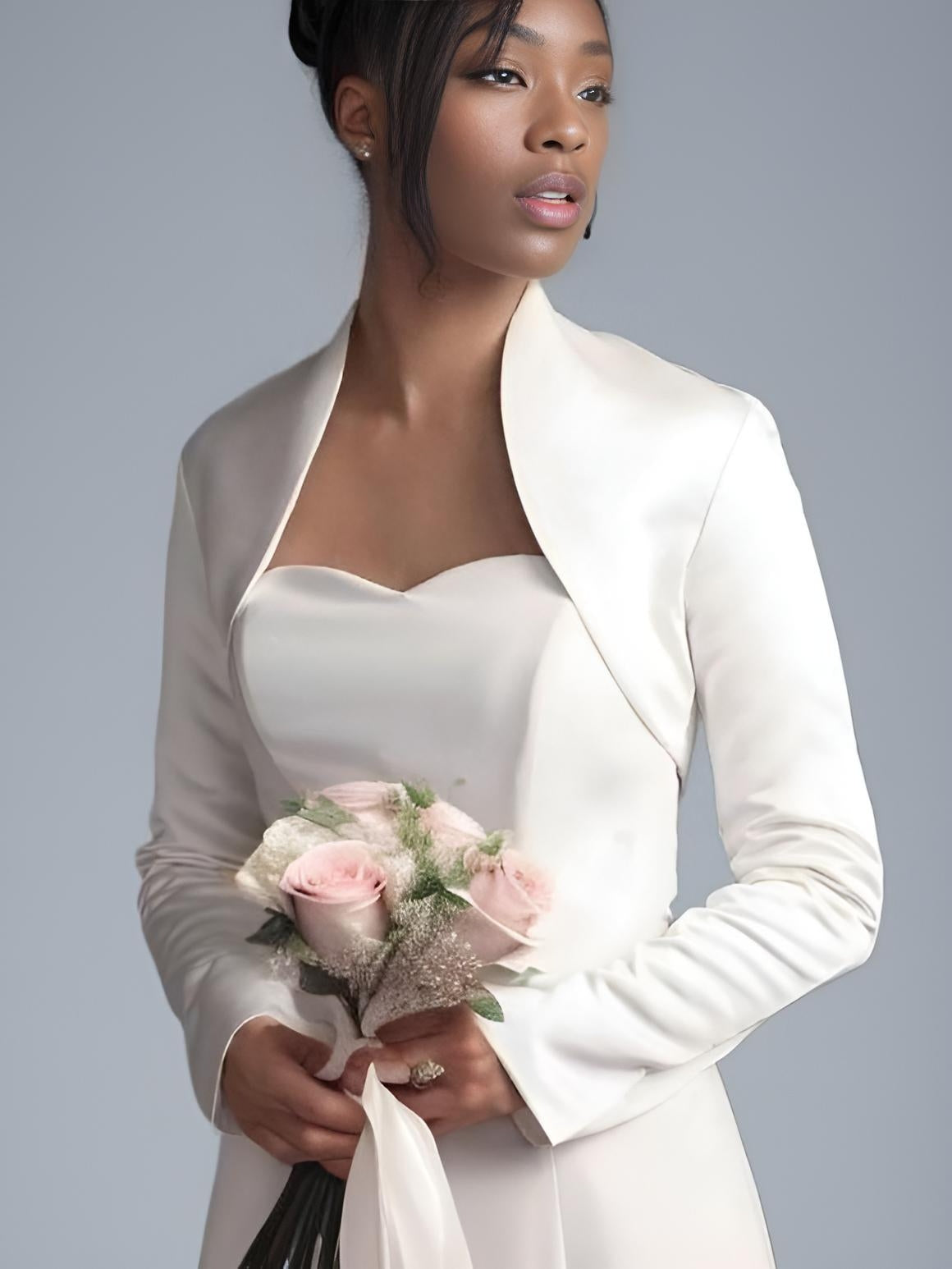Bride wearing satin bridal jacket, showing fitted sleeves and collar detail from side.