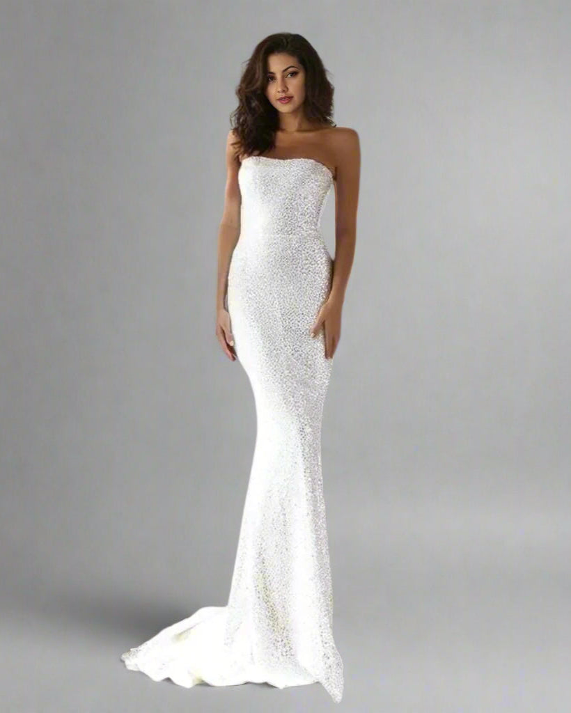 Bride posing in shiny, fitted mermaid bridal gown with dramatic detailing.