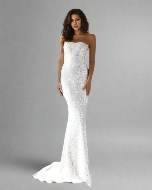 Bride posing in shiny, fitted mermaid bridal gown with dramatic detailing.