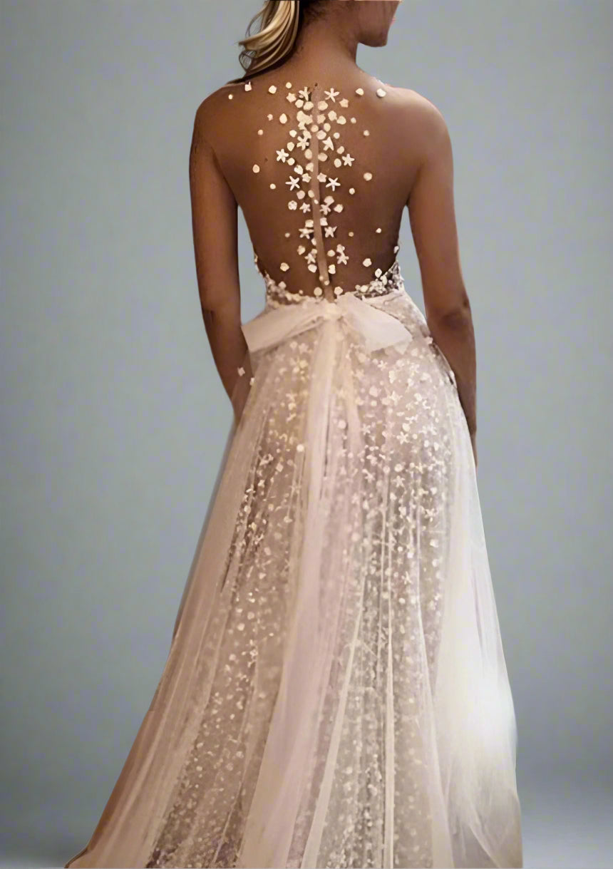 Bride showing illusion back detail on CLAIRE wedding dress with floral appliqués.