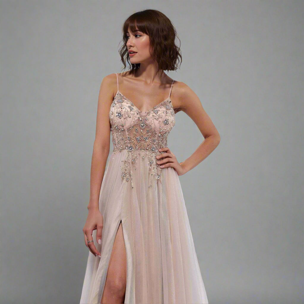Woman wearing a beige evening gown with floral embellishments on a gray background