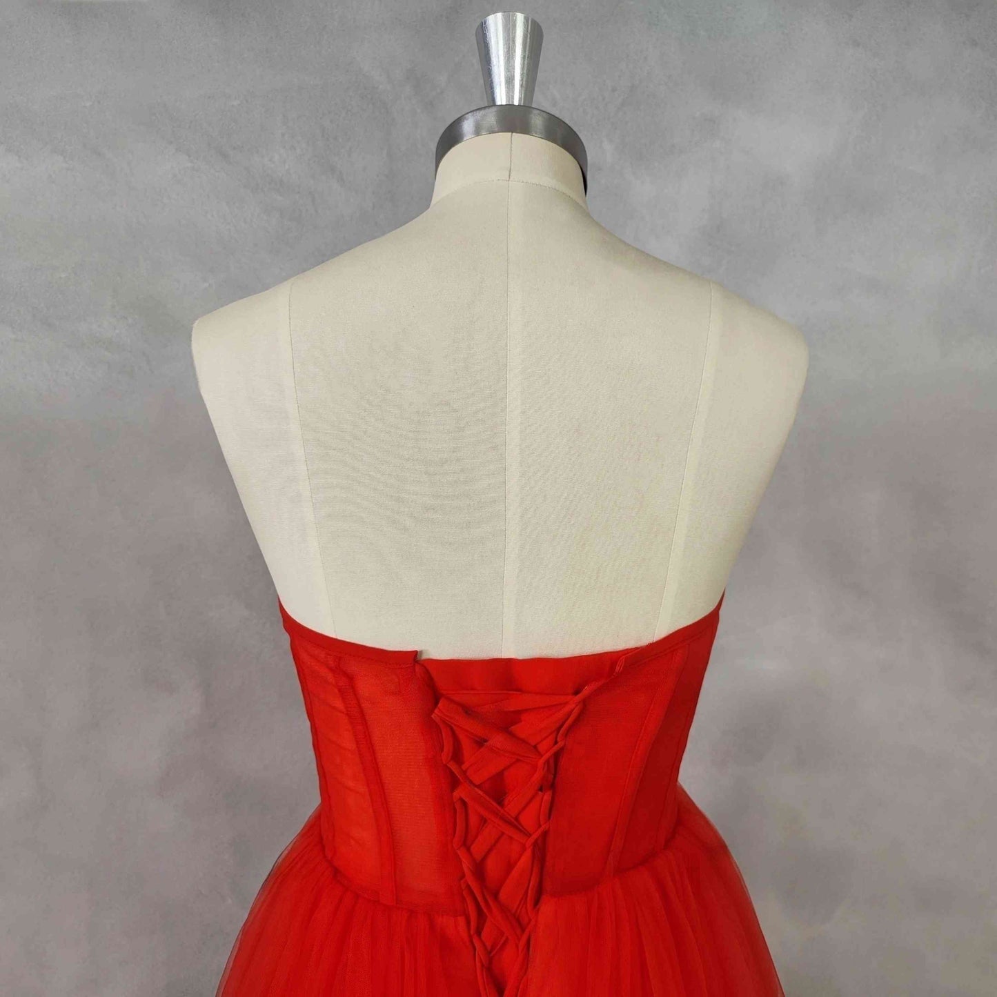 Detailed close-up of lace-up back and sweetheart neckline on red formal dress