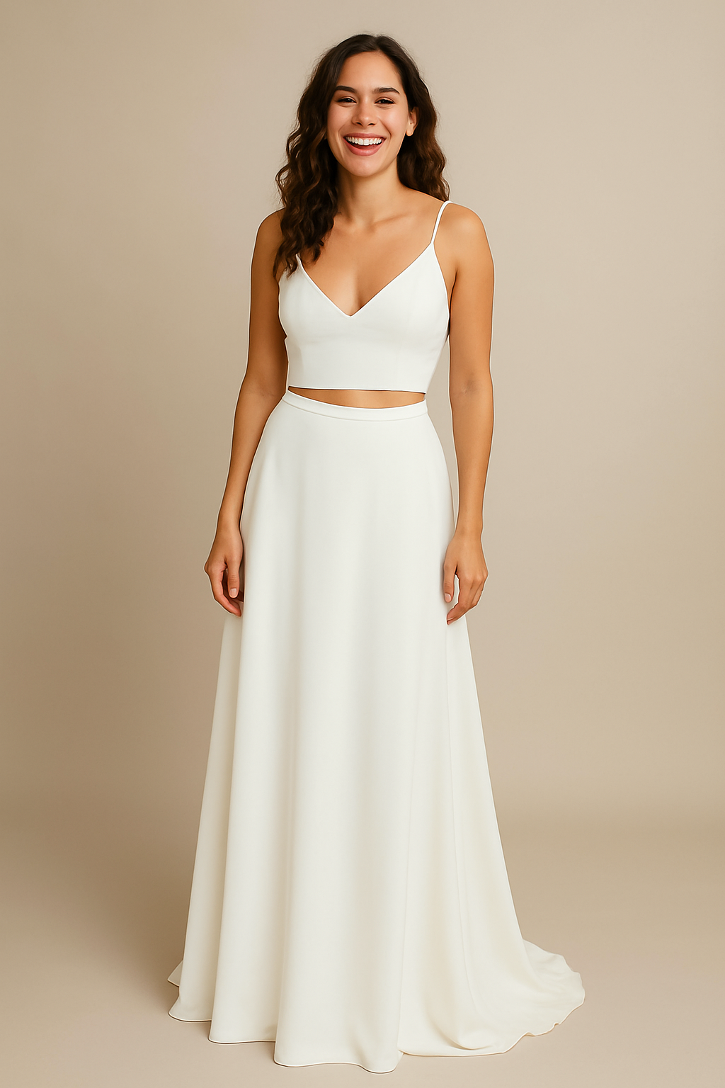Full-length view of a happy bride in the Jacey Wedding Dress – featuring a minimalist two-piece design with a fitted white top and floor-length skirt, posed in a neutral studio setting.