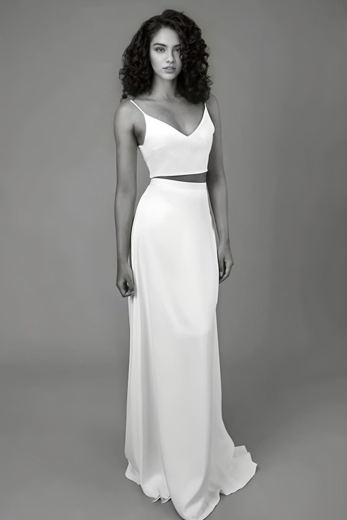 Bride wearing a satin two-piece wedding dress with a V-neck top and spaghetti straps, showcasing a modern and sexy bridal look.