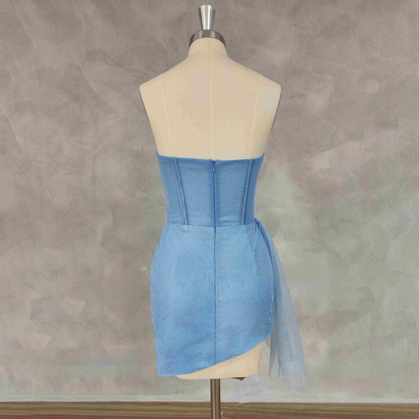The back view of the mini prom dress, emphasizing the sleek zipper design and the strapless cut.