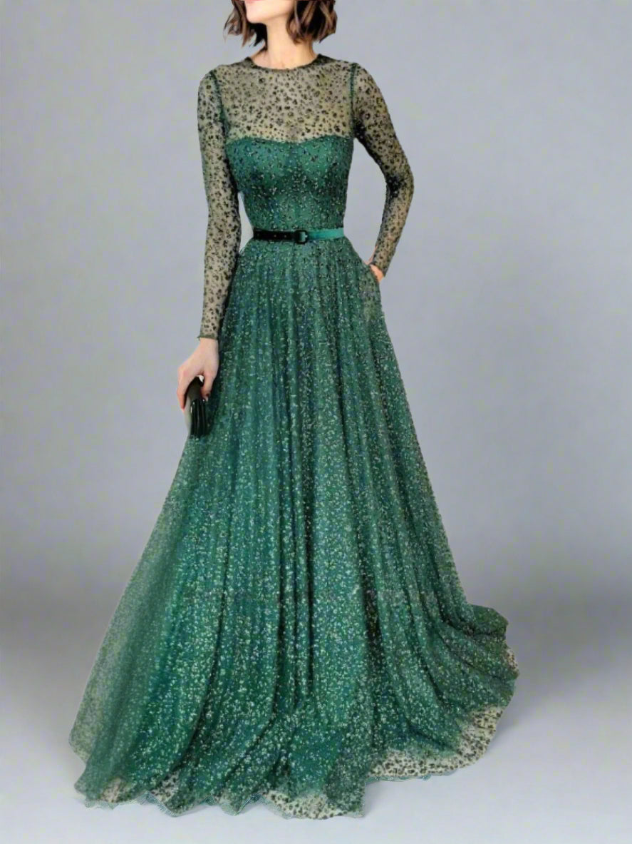 Model in emerald green A-line gown with long sleeves, posing in studio.